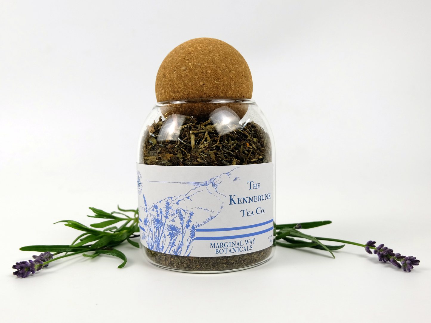 Bottle of Marginal Way tea with a cork lid, surrounded by lavender flowers on a white background