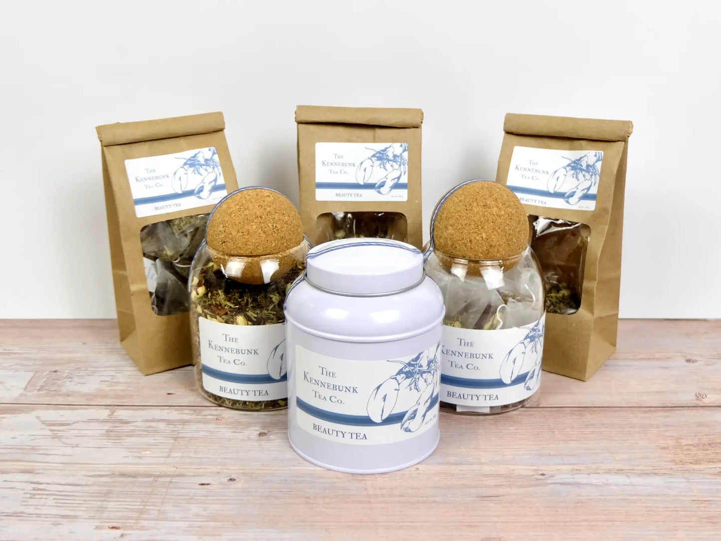 Beauty Tea loose leaf tea with refill bags, glass jars, and a tin in front, all with Lobster Label