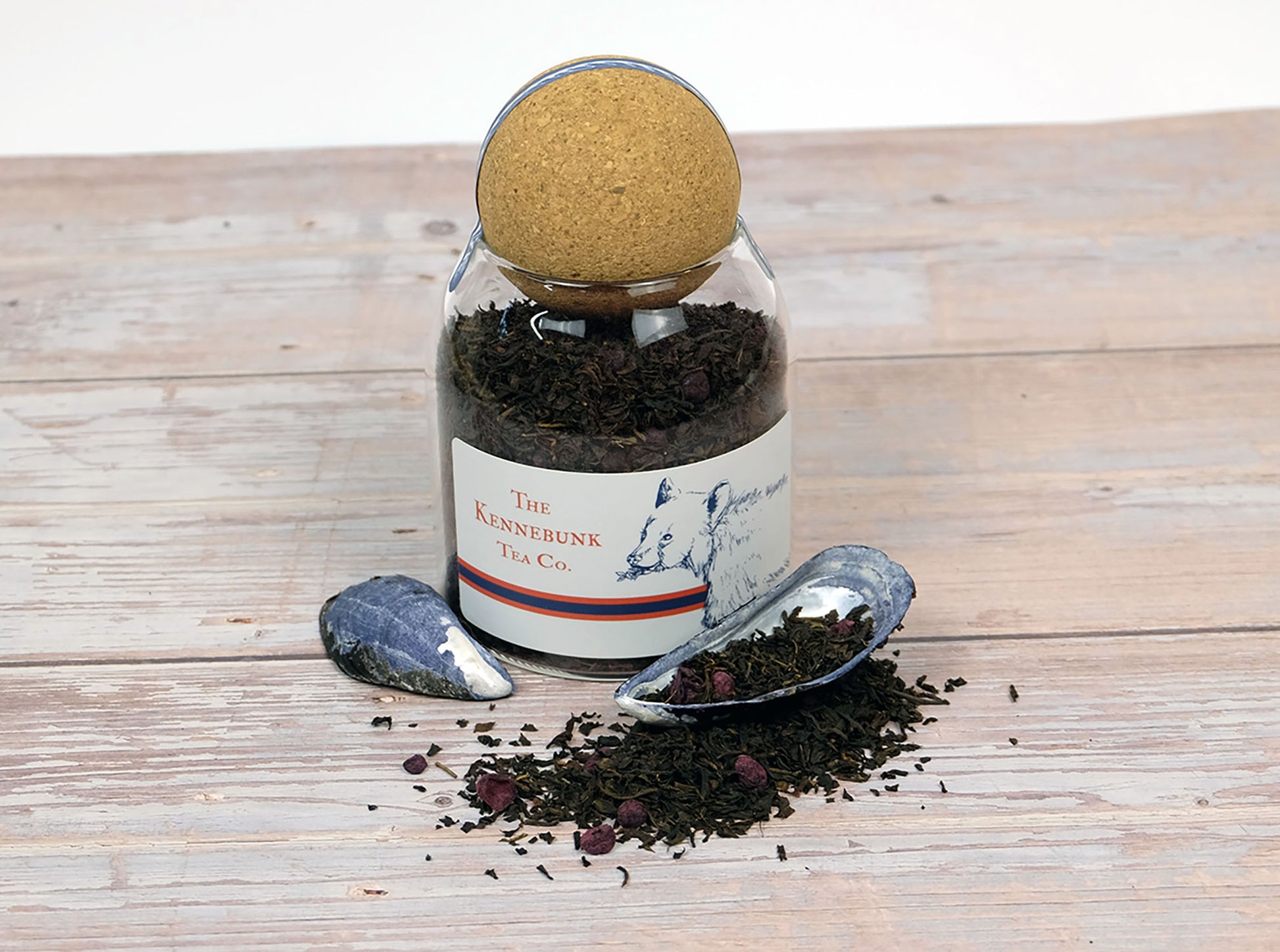 Blueberry Black Tea loose leaf tea in a glass jar with mussel shells beside it