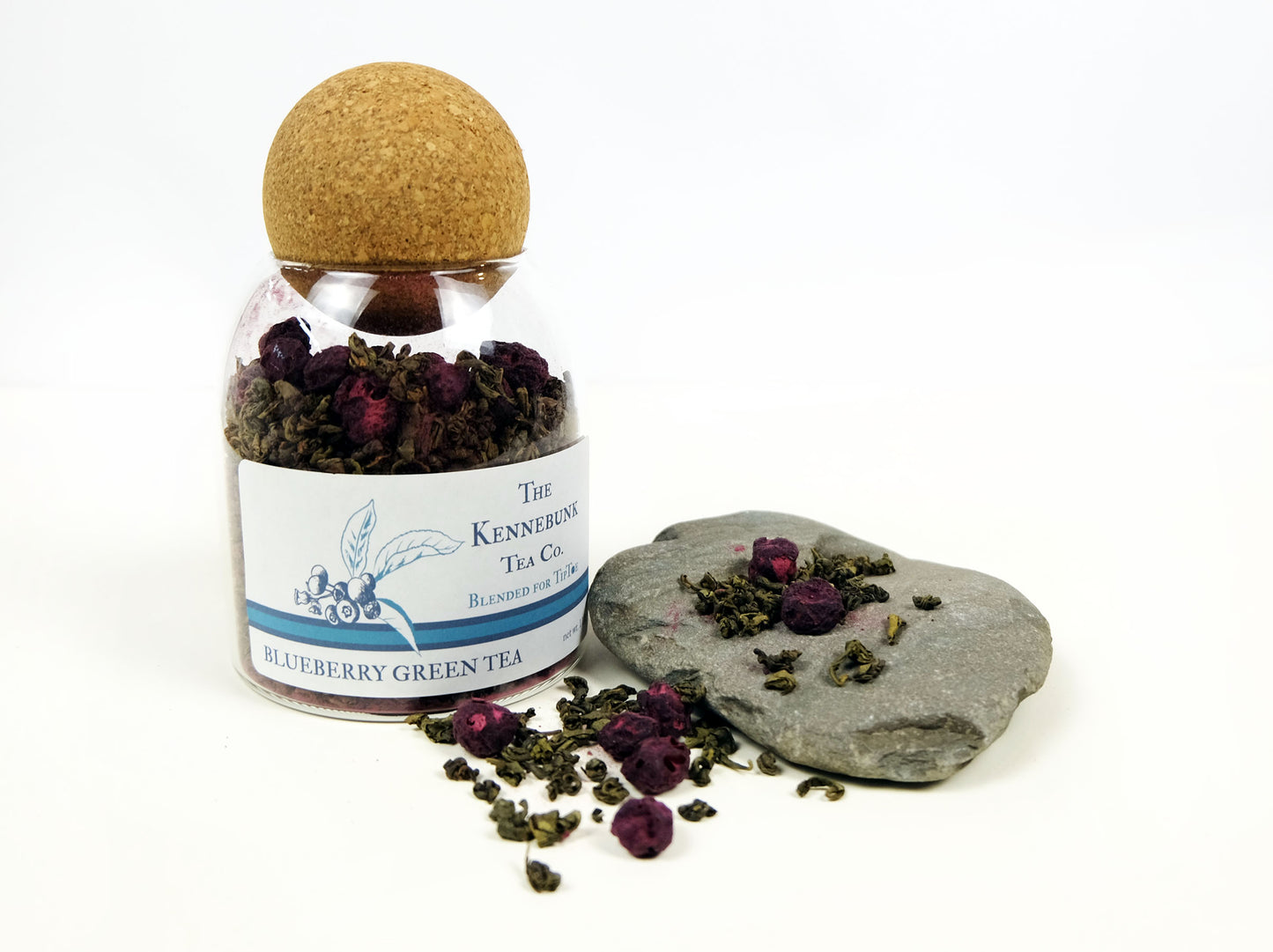 Blueberry Green Tea loose leaf tea in a glass jar and on a rock