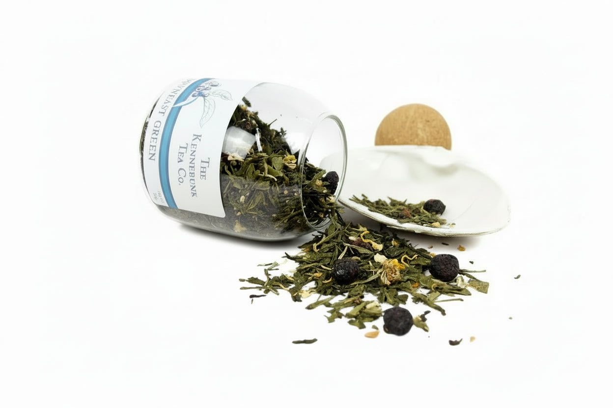 Downeast Green Tea loose leaf tea spilling from a glass jar onto a white shell