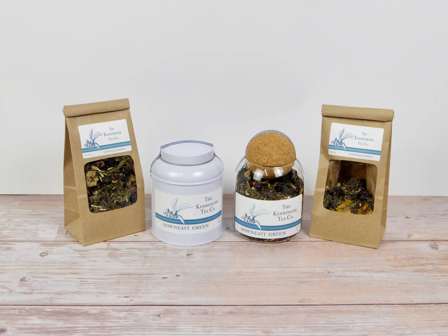 Downeast Green Tea loose leaf tea with two refill tea bags next to a tin and glass jar, all with Blueberry labels