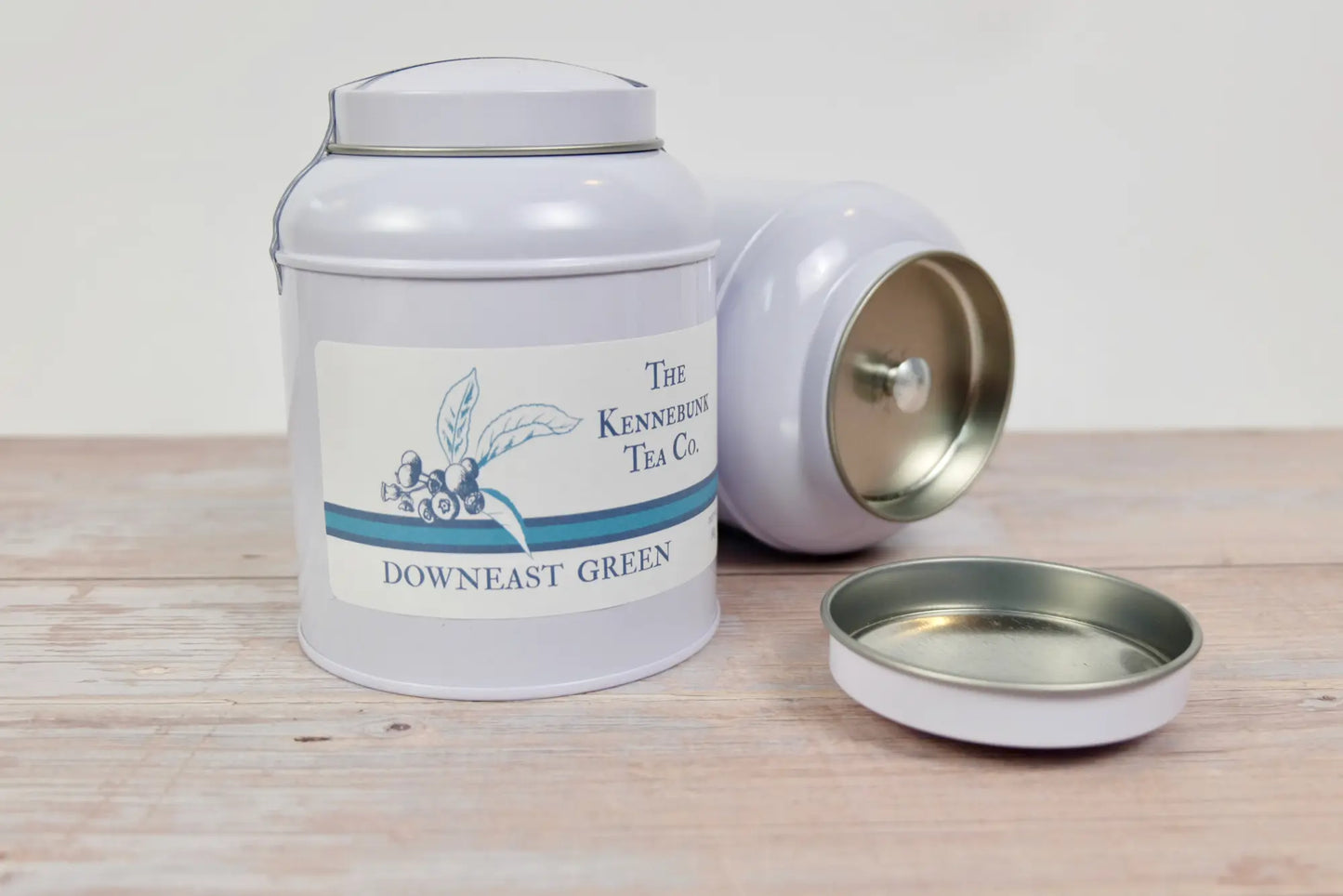 Downeast Green Tea loose leaf tea in two tins, one lying on its side, with Blueberry labels