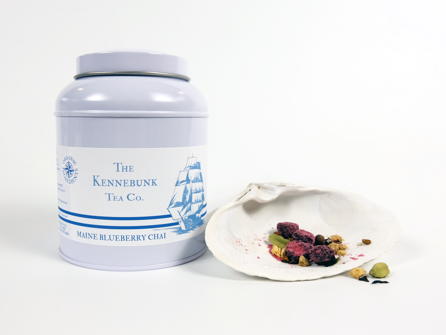 Maine Blueberry Chai loose leaf tea in a tin with a white shell beside it