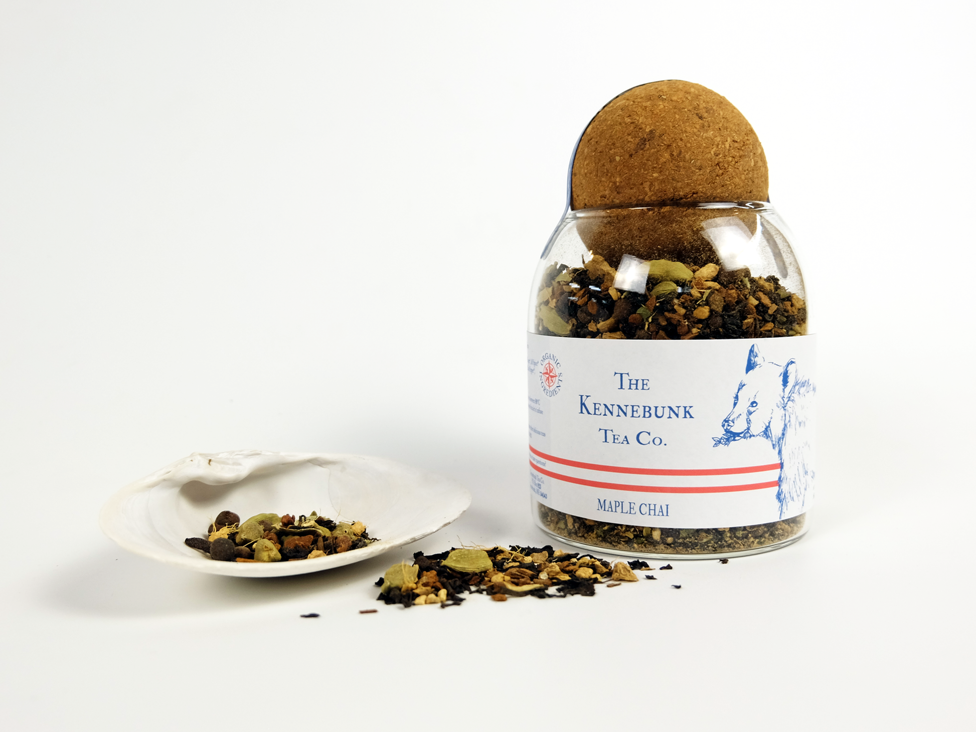 Maple Chai loose leaf tea in a glass jar with a white shell beside it