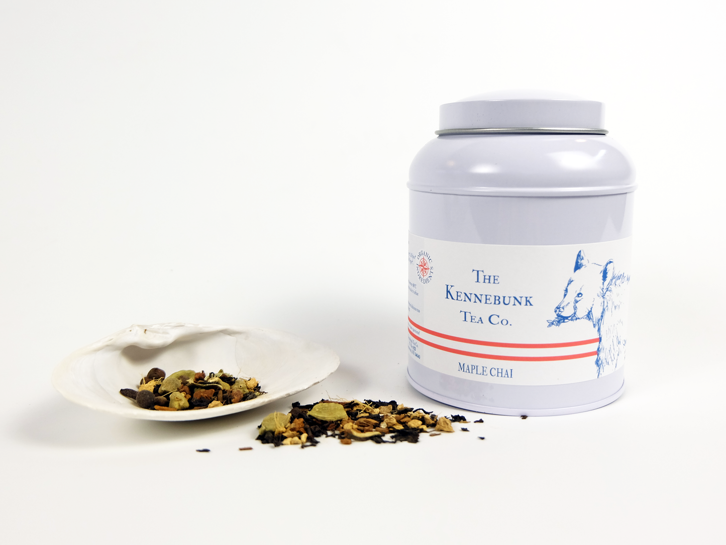 Maple Chai loose leaf tea in a tin with a white shell beside it