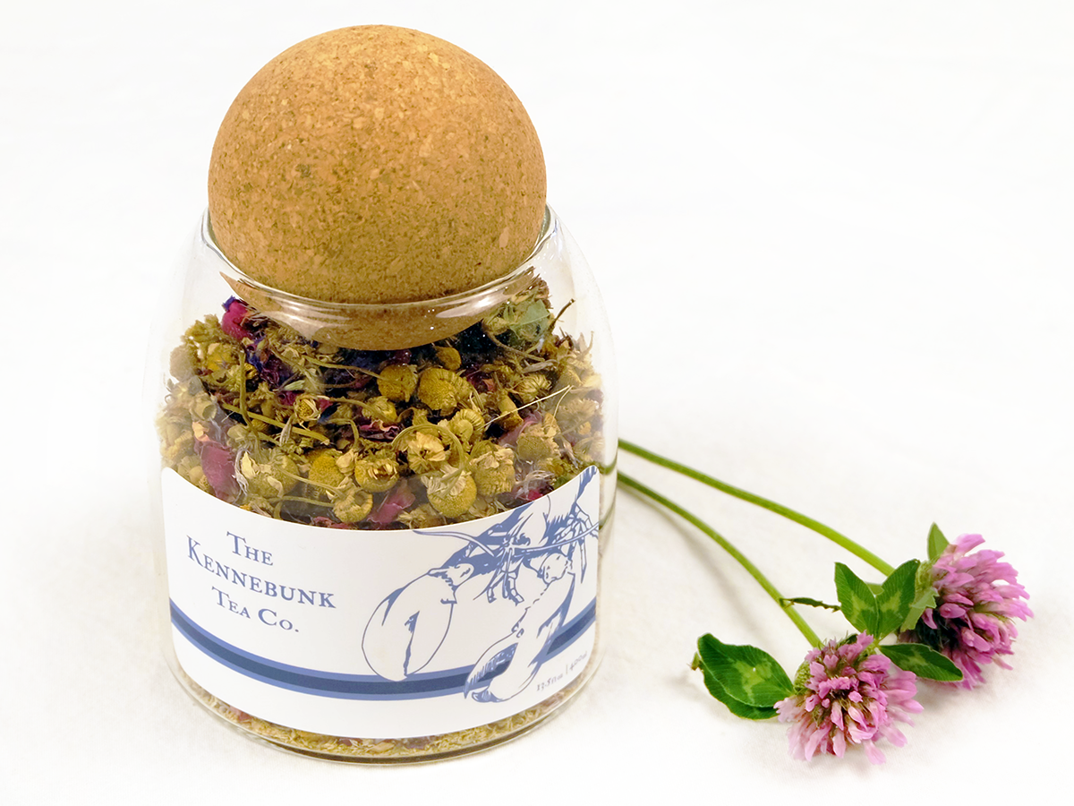 New England Garden Tea loose leaf tea in a glass jar with clover blossoms beside it, Lobster label