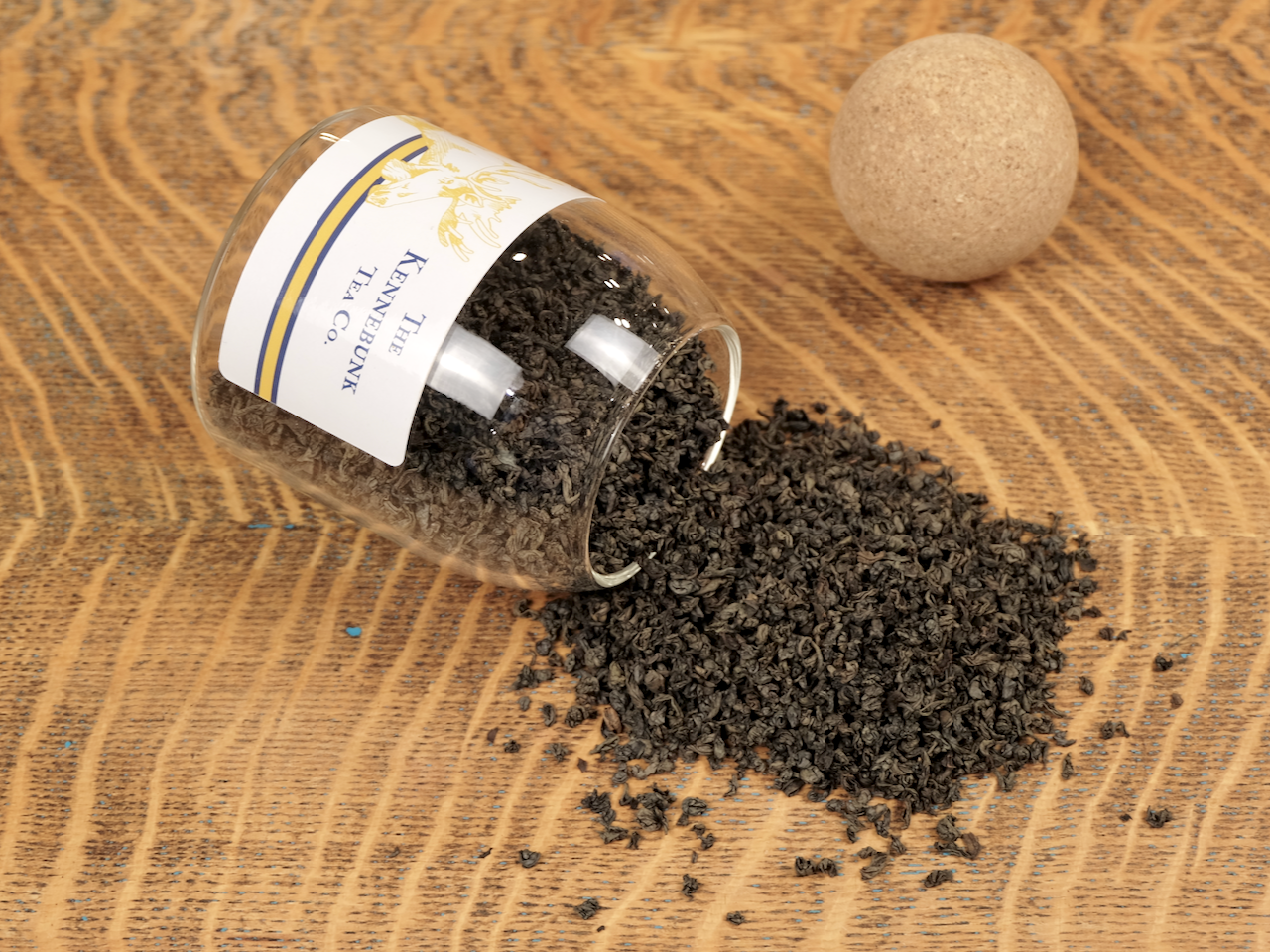 Organic Black Tea loose leaf tea spilling from a glass jar with cork top and moose label