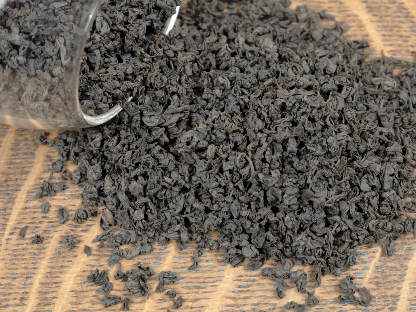 Organic Black Tea loose leaf tea spilling from a glass jar, close-up