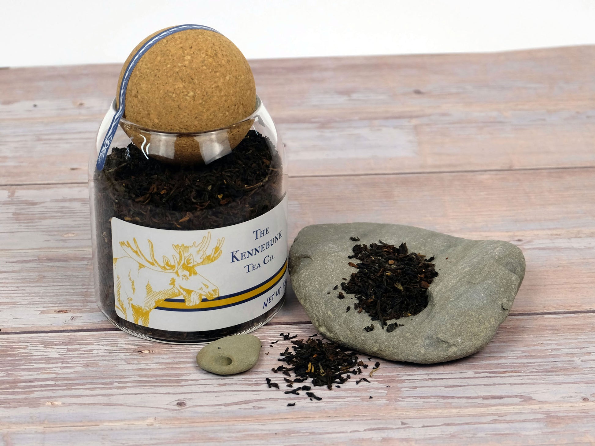 Organic Darjeeling Tea loose leaf tea in a glass jar with rocks around it