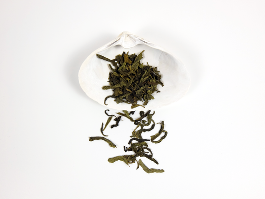Organic Dragon Well Tea loose leaf tea on a white shell