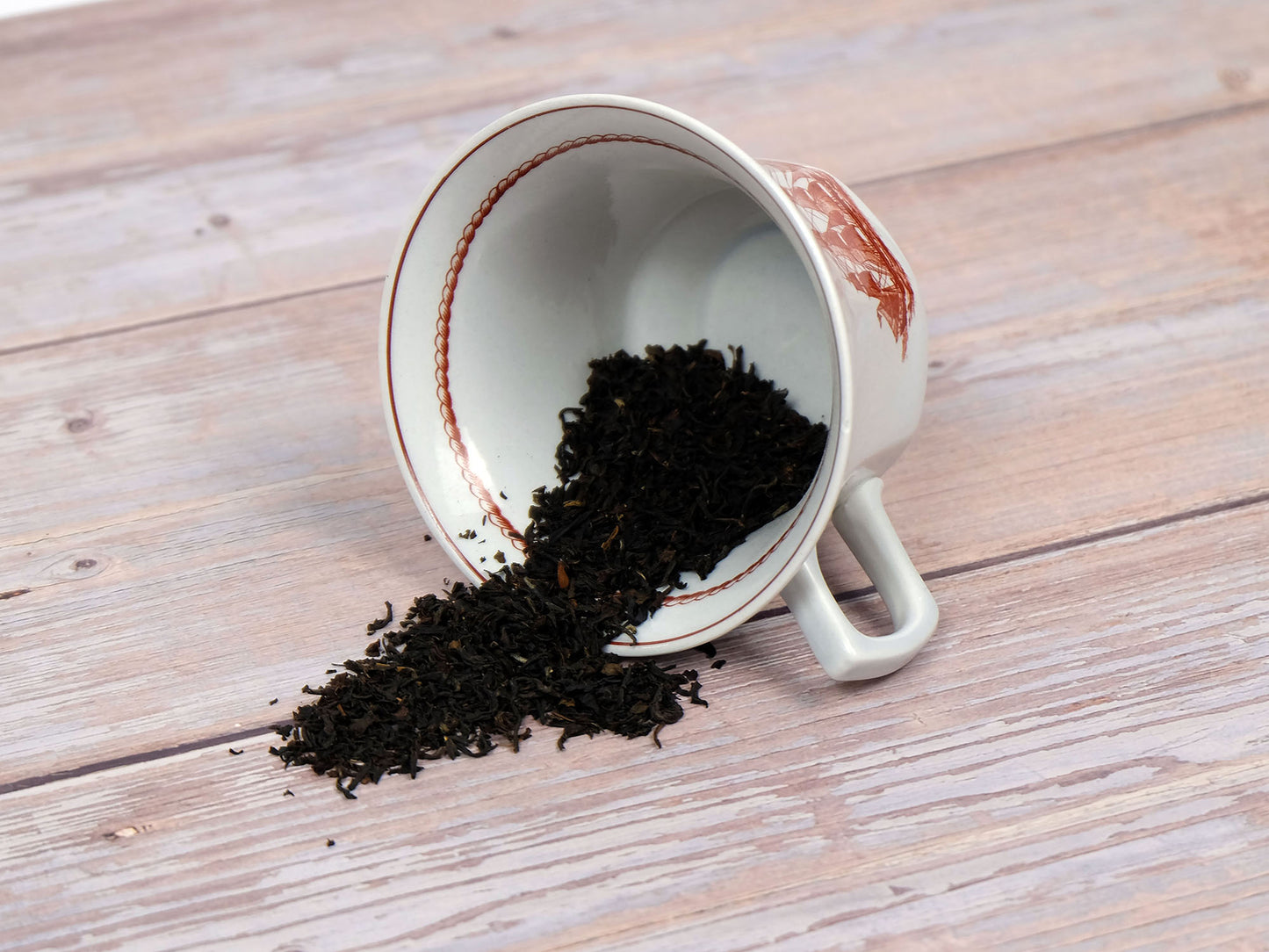 Organic English Breakfast Tea loose leaf tea spilling from a teacup