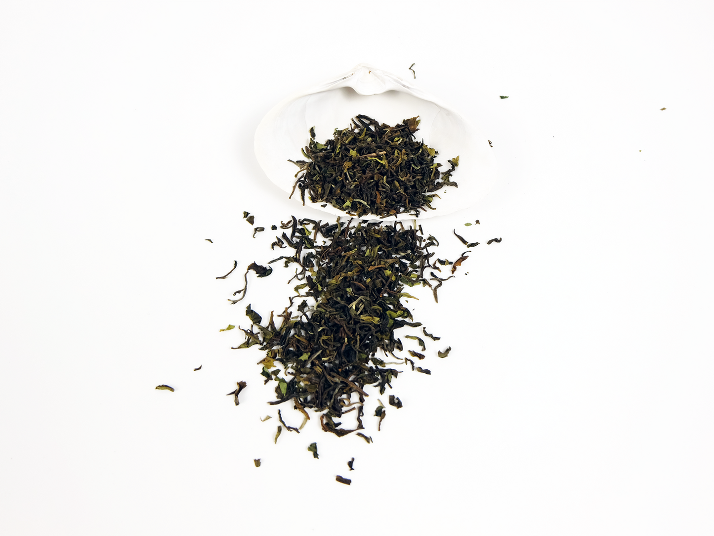 Orange Valley first flush Darjeeling loose leaf tea in a white shell, leaves spilling over the side