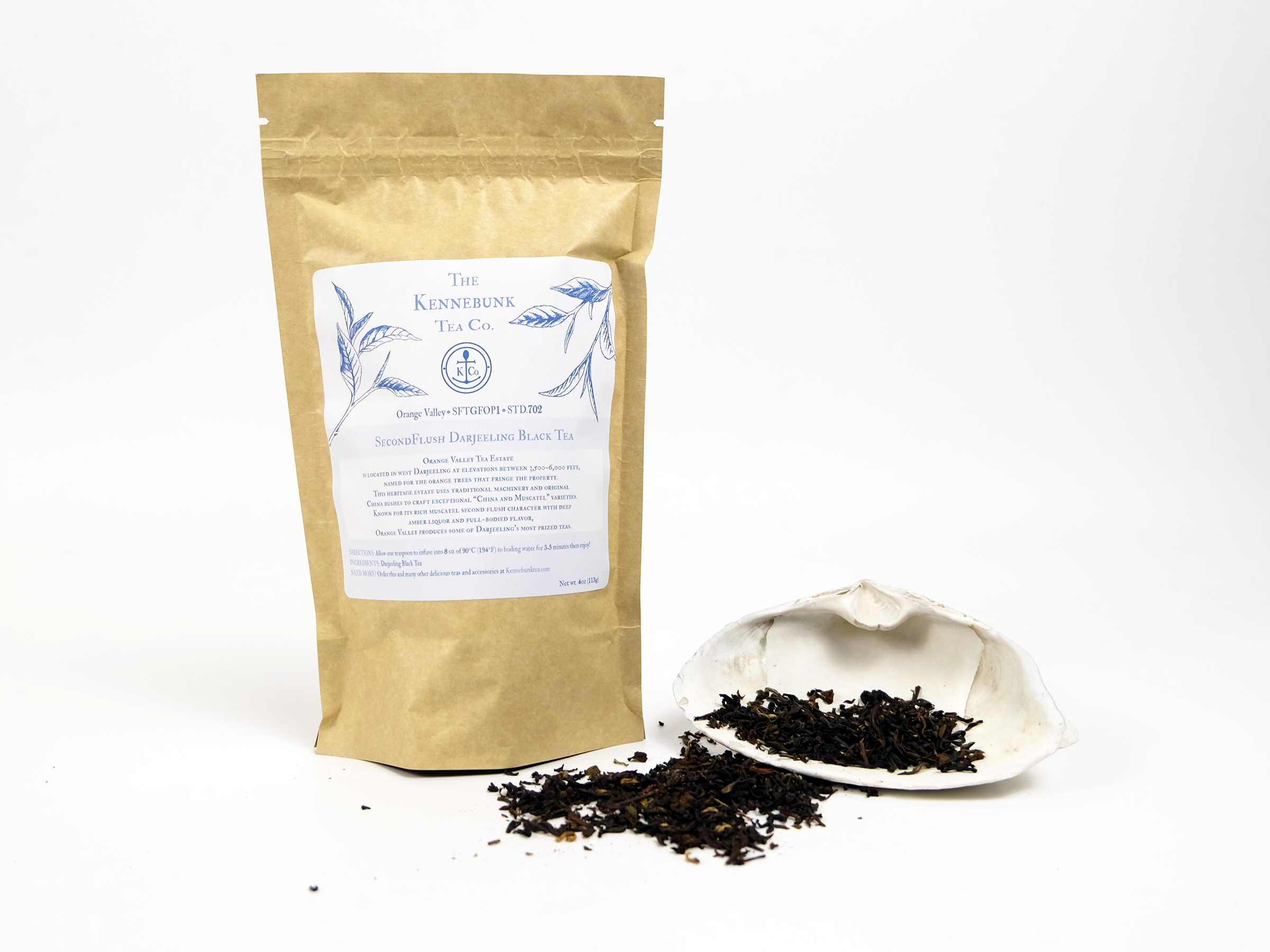 Orange Valley second flush Darjeeling loose leaf tea on a white shell with 4oz kraft tea bag behind