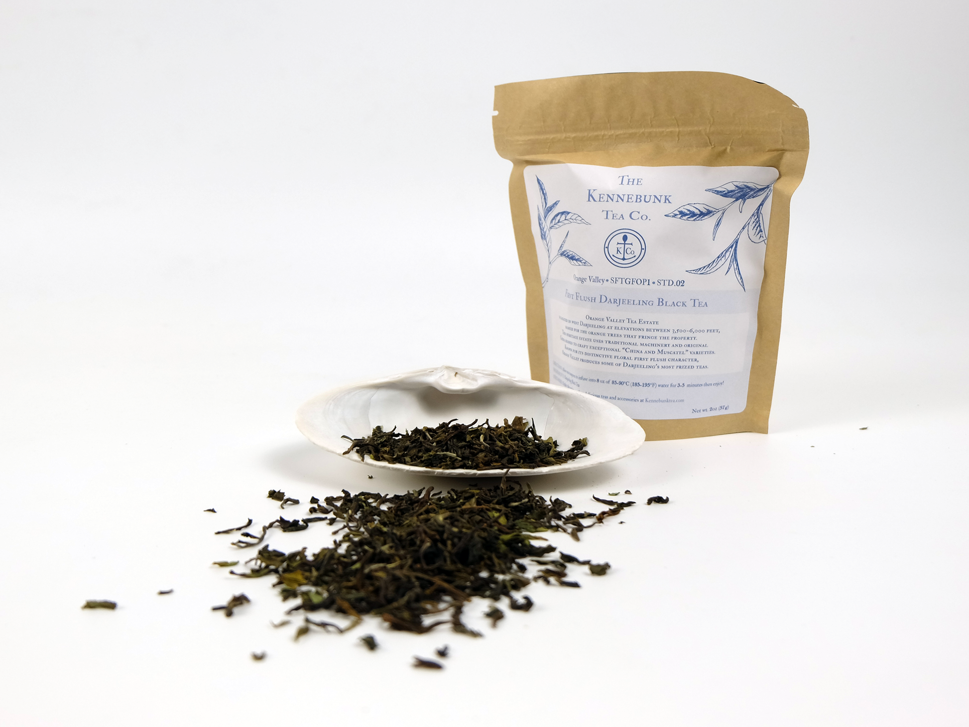 Orange Valley first flush Darjeeling loose leaf tea on a white shell with 2oz kraft tea bag